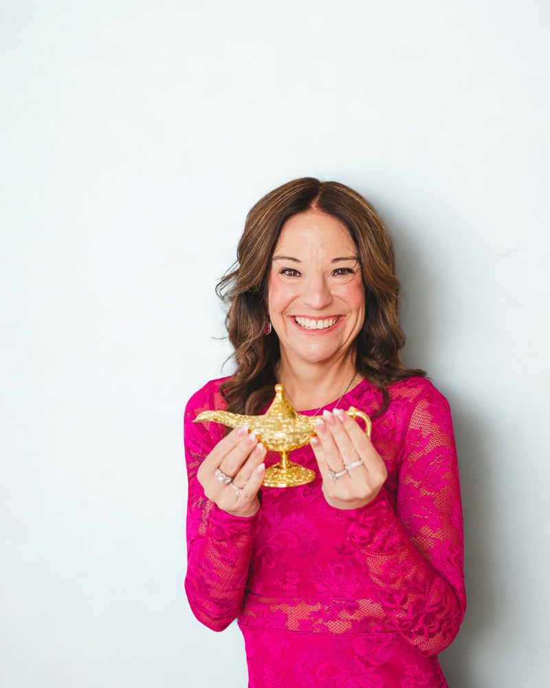 Jamie, founder of Not So Wimpy Teacher, smiling and holding a golden genie lamp